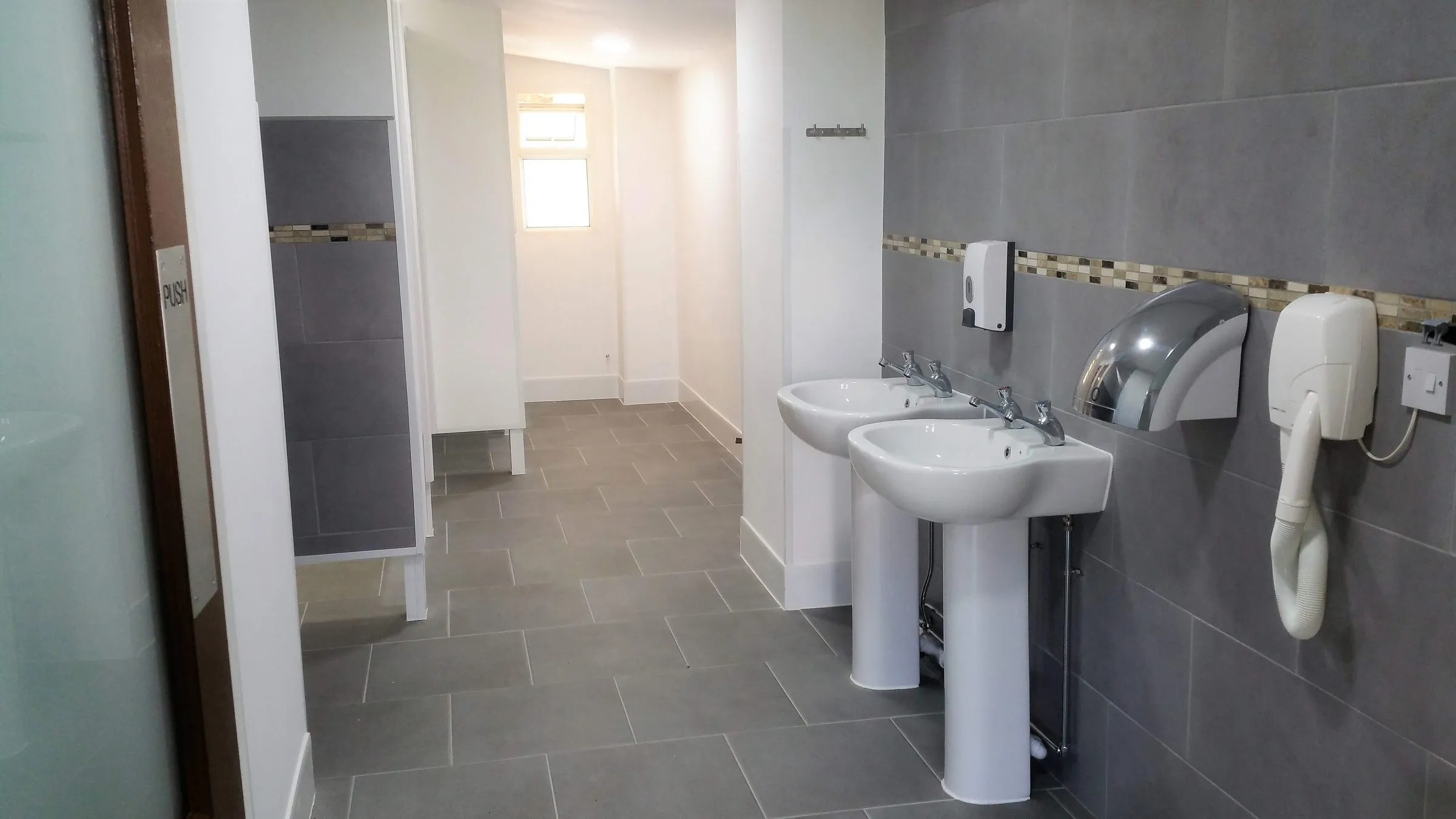 Washroom with basins, hand dryer and hairdryer